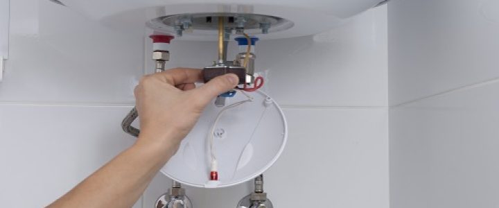 master holds a thermostat from an electric boiler in his hand